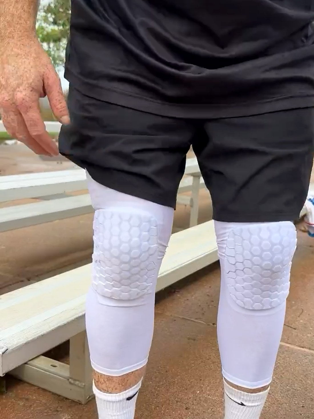 Both legs in clean white FlexCell sliding knee sleeves, honeycomb pads over each knee